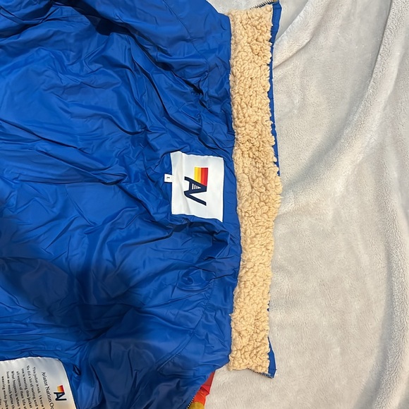 Jacket is Blue with a rainbow going across the chest. It is a Children’s size L. - Picture 4 of 4